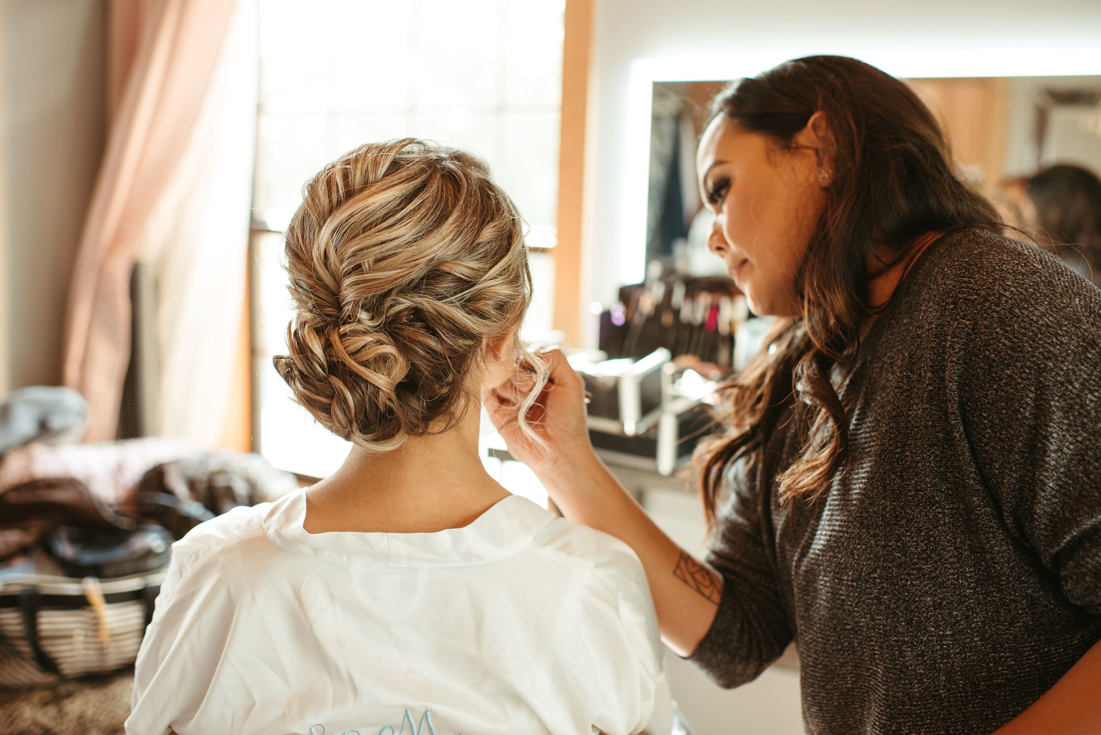 Bridal artist finishing a textured updo for a Florida wedding morning