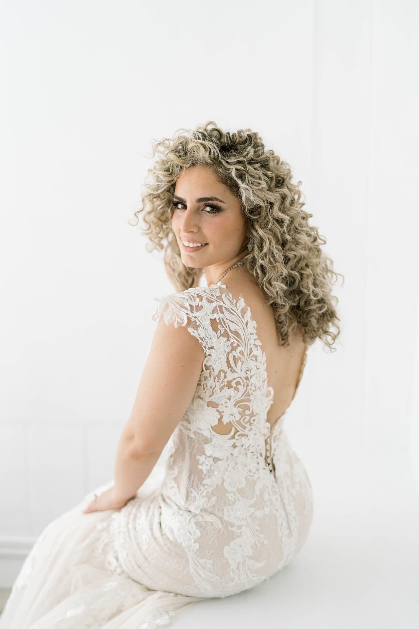 Defined curly bridal hairstyle with soft face-framing pieces