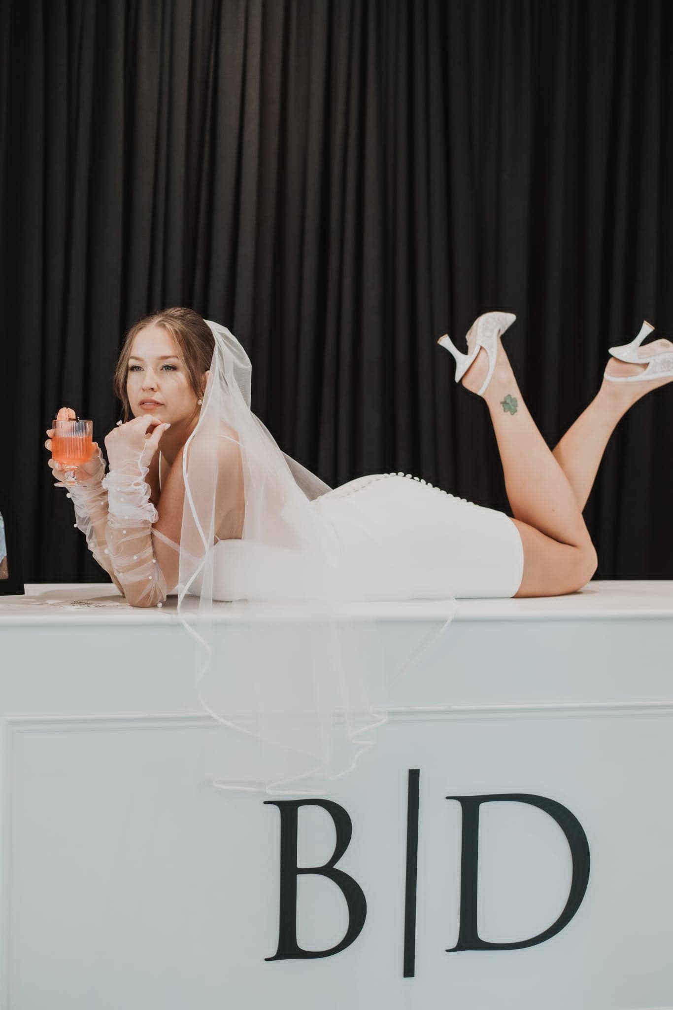 Bride with a polished updo and veil, hair and makeup still fresh hours into the reception