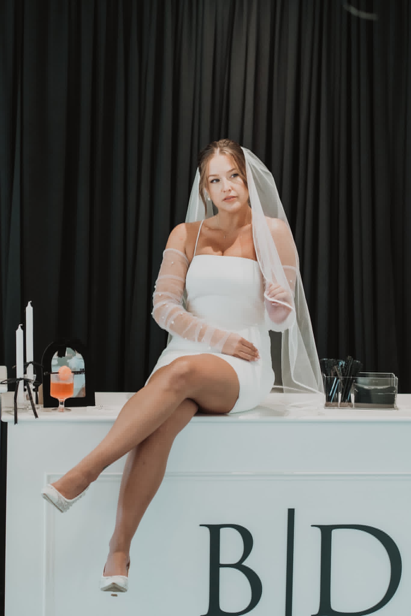 Bride laughing at the bar in her reception dress, hair and makeup styled to last the full day