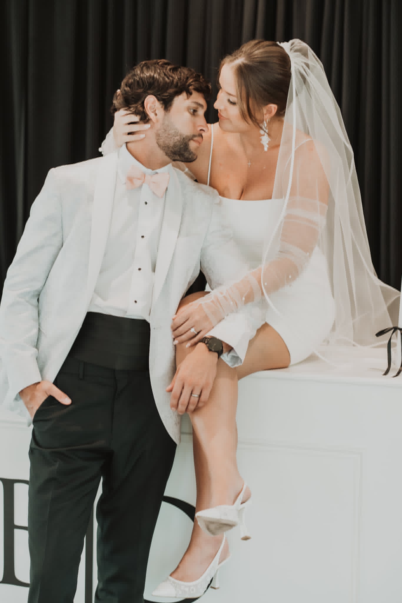 Bride and groom embracing at the reception bar, her hair and makeup holding through the celebration