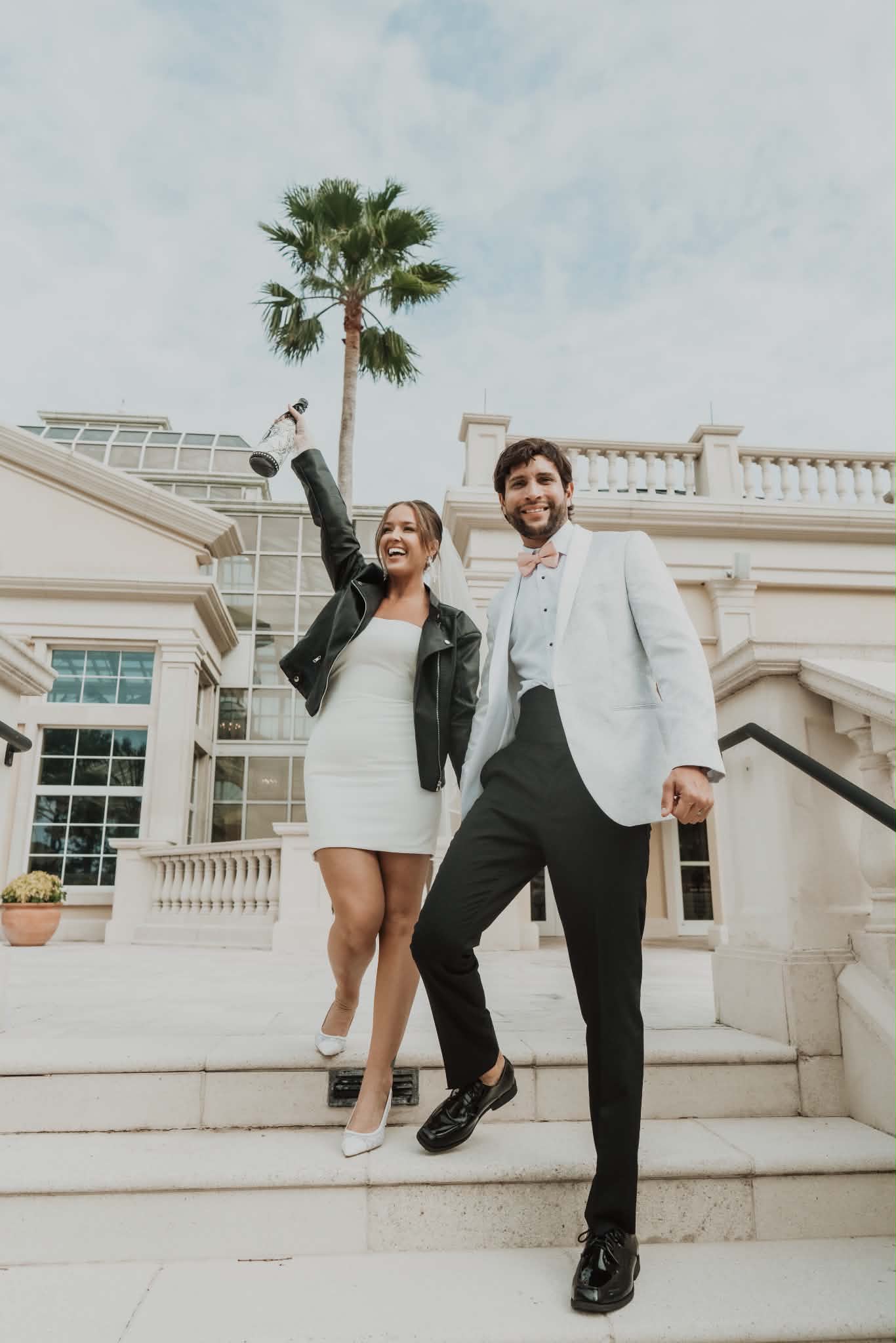 Bride and groom celebrating on the venue steps after their wedding